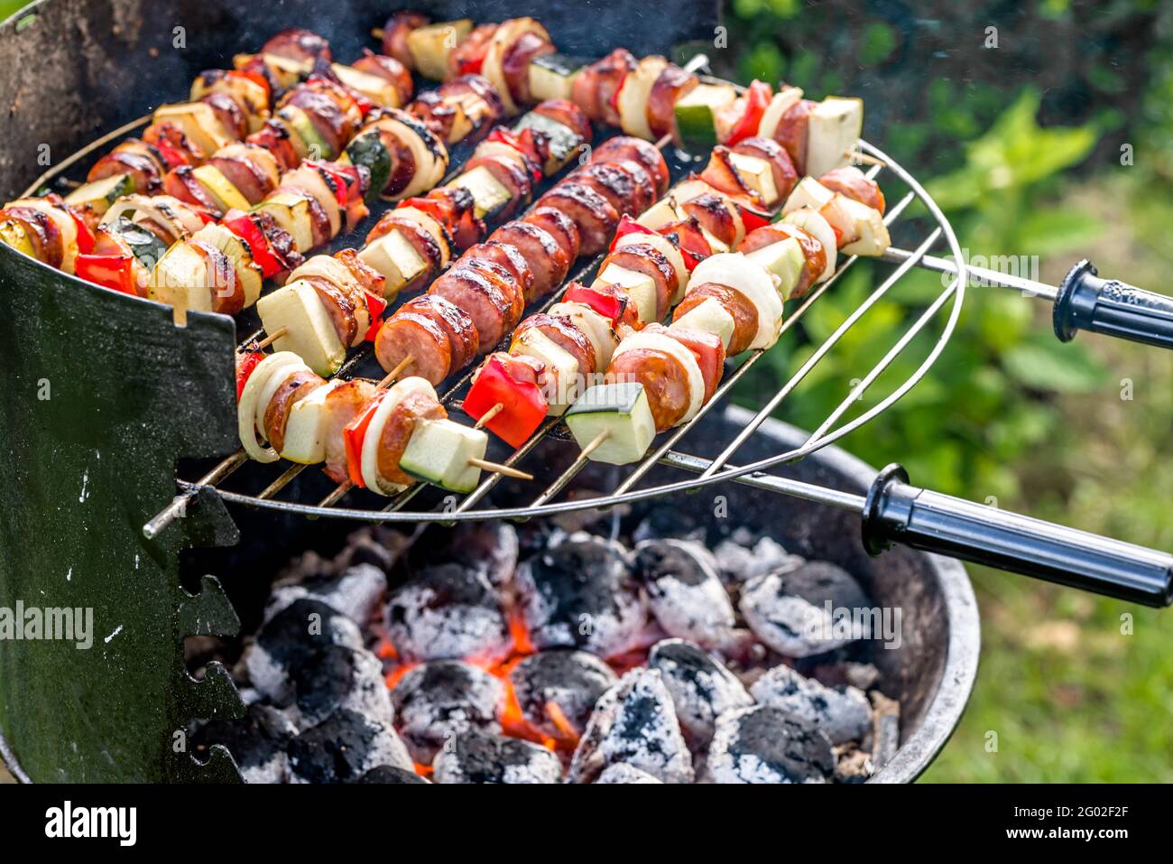 Verdure e spiedini di carne alla griglia con piatti caldi, grigliando  all'aperto nel cortile estivo Foto stock - Alamy
