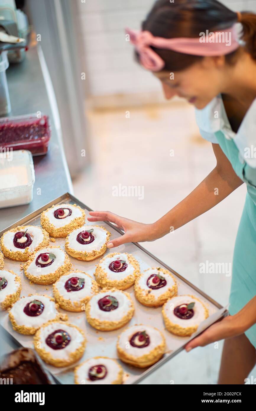 Allegro proprietario di piccola impresa è appassionato circa il suo prodotto / ciambelle Foto Stock
