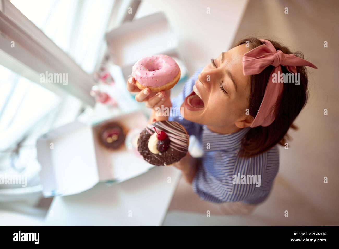 Il proprietario di piccola impresa è appassionato circa il suo prodotto appetitoso/ciambelle Foto Stock