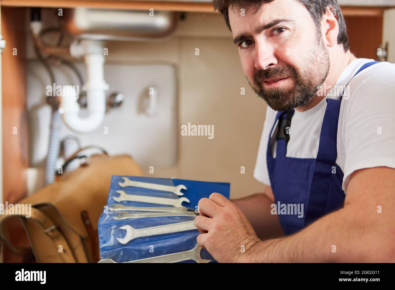 Uomo di mano con chiavi prima di una riparazione difficile nel bagno Foto Stock