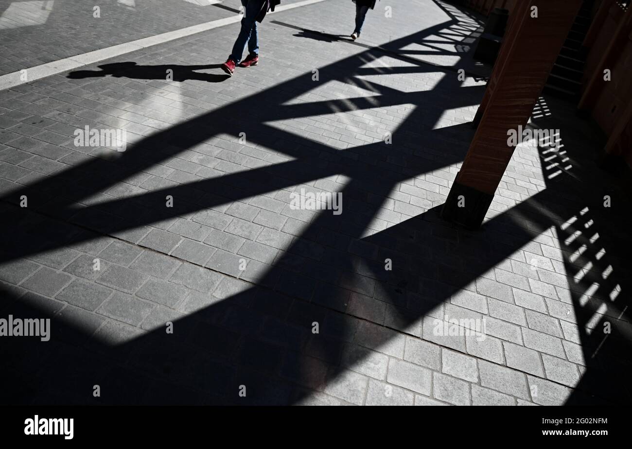 31 maggio 2021, Hessen, Francoforte sul meno: Un gioco d'ombra sul marciapiede è creato dalla pergola di Krönungsweg e da due passanti nel nuovo centro storico di Francoforte. Foto: Arne Dedert/dpa Foto Stock