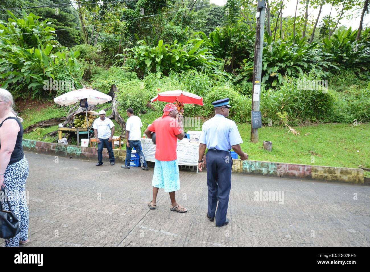 Poliziotto e uomo con ombrellone Carriacou Isola dei Caraibi Foto Stock