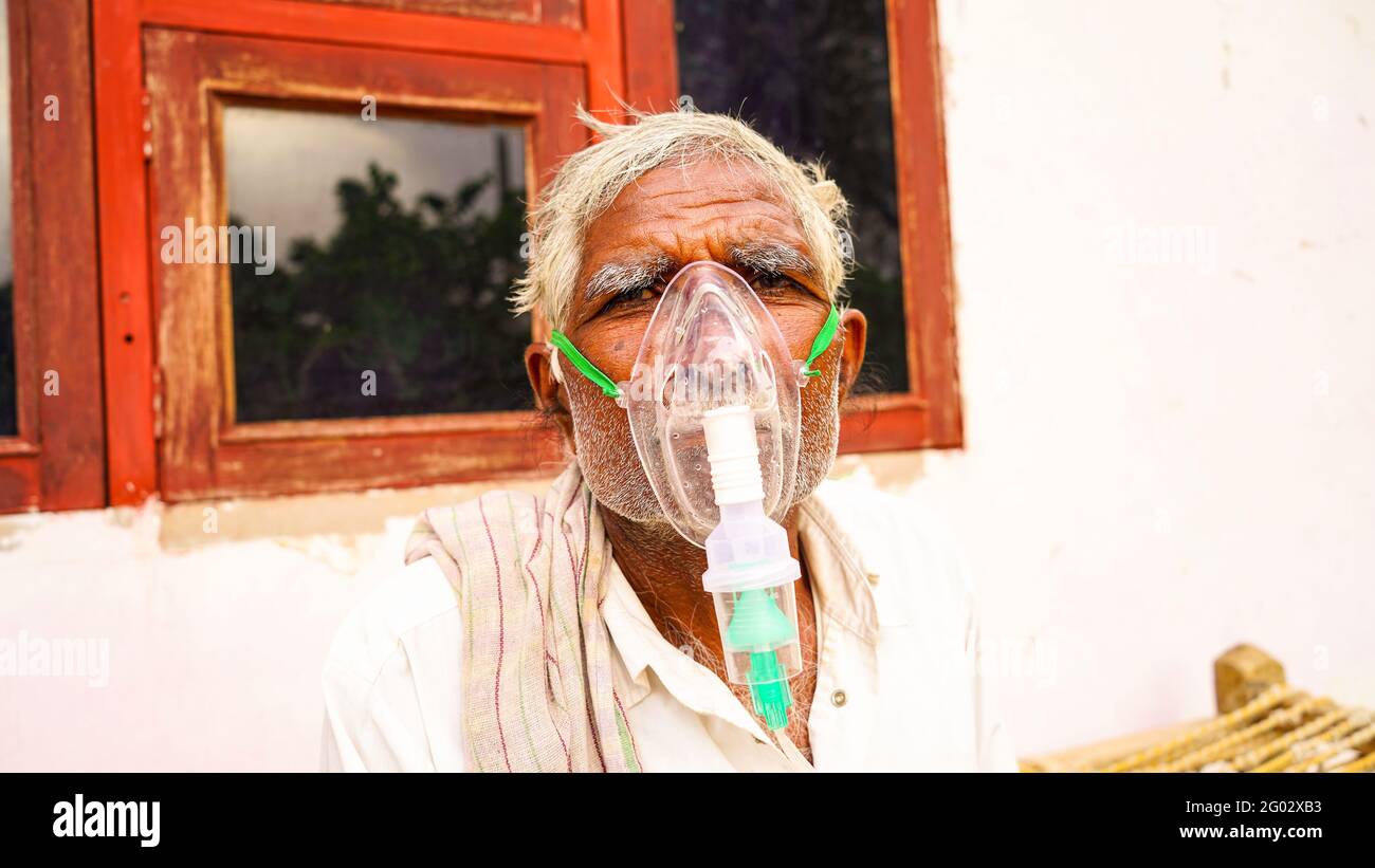 20 maggio 2021 - Reengus, Sikar, India. Una persona anziana infettata dalla malattia di Covid 19. Maschera per l'inalazione di ossigeno con flusso di ossigeno liquido. Foto Stock