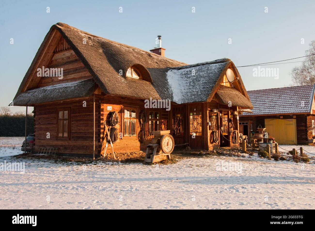 Polonia Gennaio - 2017: Bella casa di legno con tetto di paglia nei raggi del sole invernale. Edificio vecchio e originale che e' stato rinnovato. Europa orientale. Foto Stock