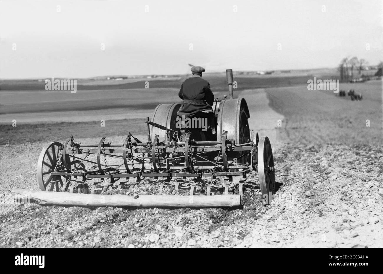 Il coltivatore arina i campi in primavera con il nuovo trattore Foto Stock