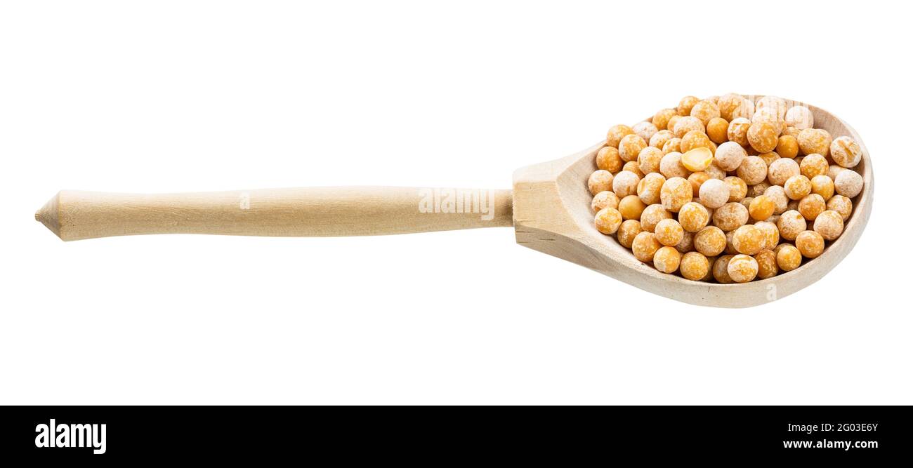 cucchiaio di legno con piselli gialli interi secchi isolati su bianco sfondo Foto Stock