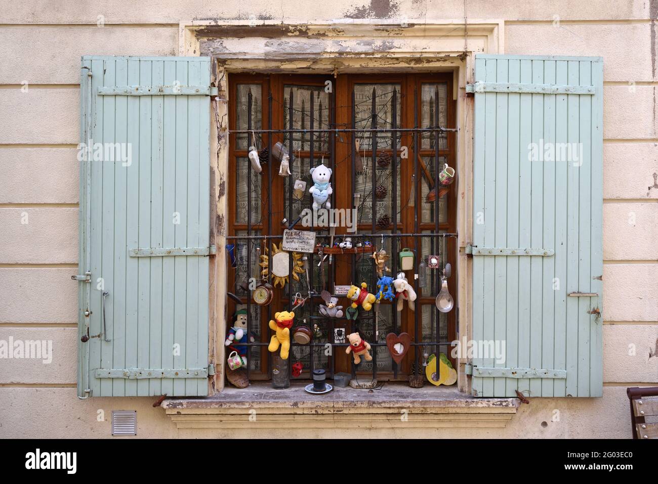 Curiosa o insolita finestra di casa cittadina decorata con Knick-Knacks e giocattoli coccolati nella città vecchia Saint Remy de Provence Provence France Foto Stock