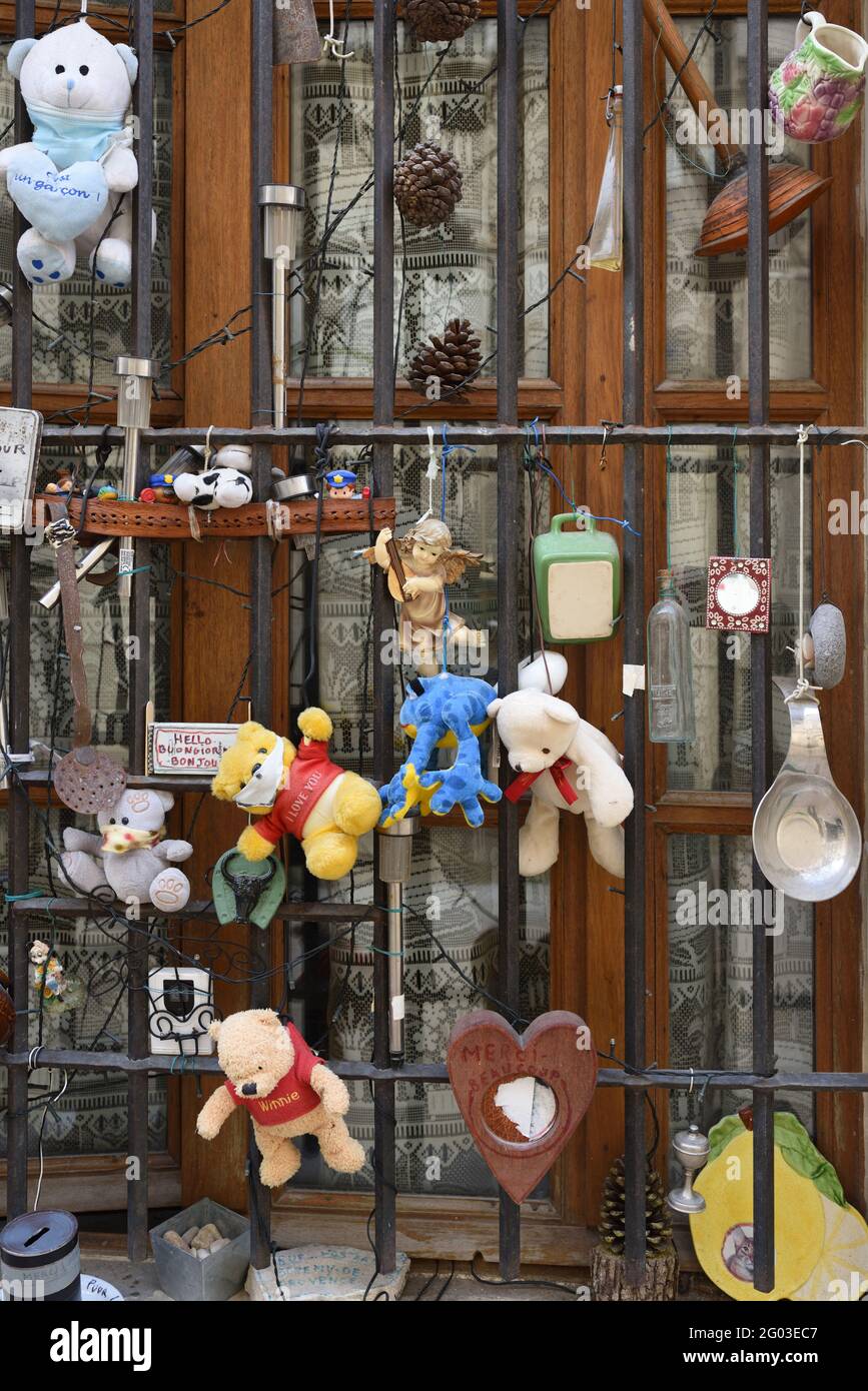 Curiosa o insolita finestra di casa cittadina decorata con Knick-Knacks e giocattoli coccolati nella città vecchia Saint Remy de Provence Provence France Foto Stock