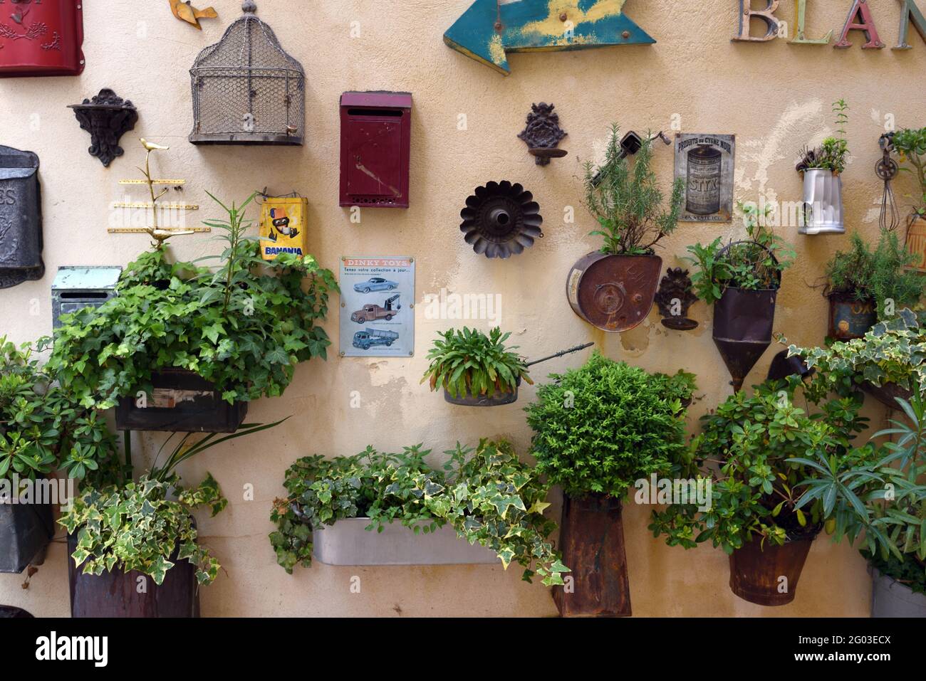 Assortimento o esposizione di piantatrici da parete vintage o riciclate, scatole di lettere e contenitori di fiori riutilizzati Saint Remy de Provence France Foto Stock