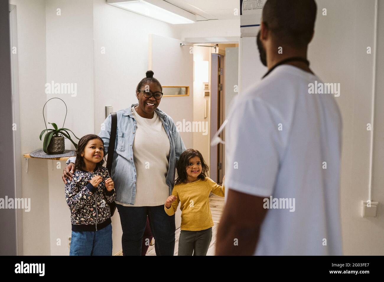 Madre felice con le figlie che visitano la clinica medica Foto Stock