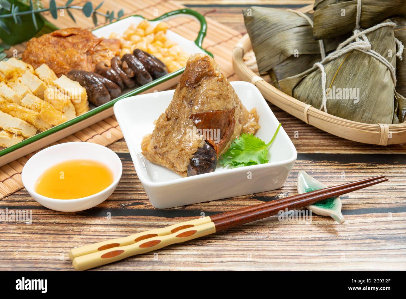 Gnocchi di riso è un piatto di riso cinese tradizionale fatto di riso glutinoso e avvolto in foglie di bambù, Dragon Boat Festival sta facendo e mangiando zongzi Foto Stock