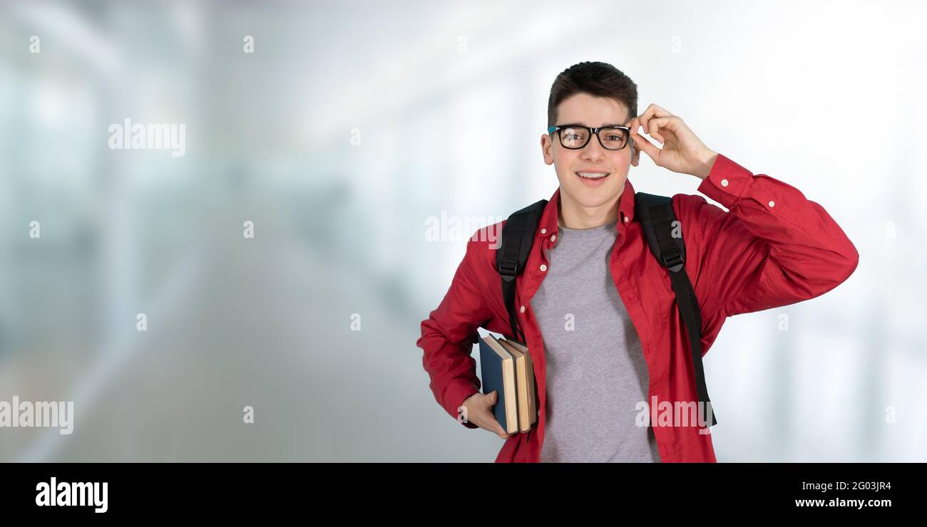 studente adolescente con libri di occhiali e zaino a scuola Foto Stock