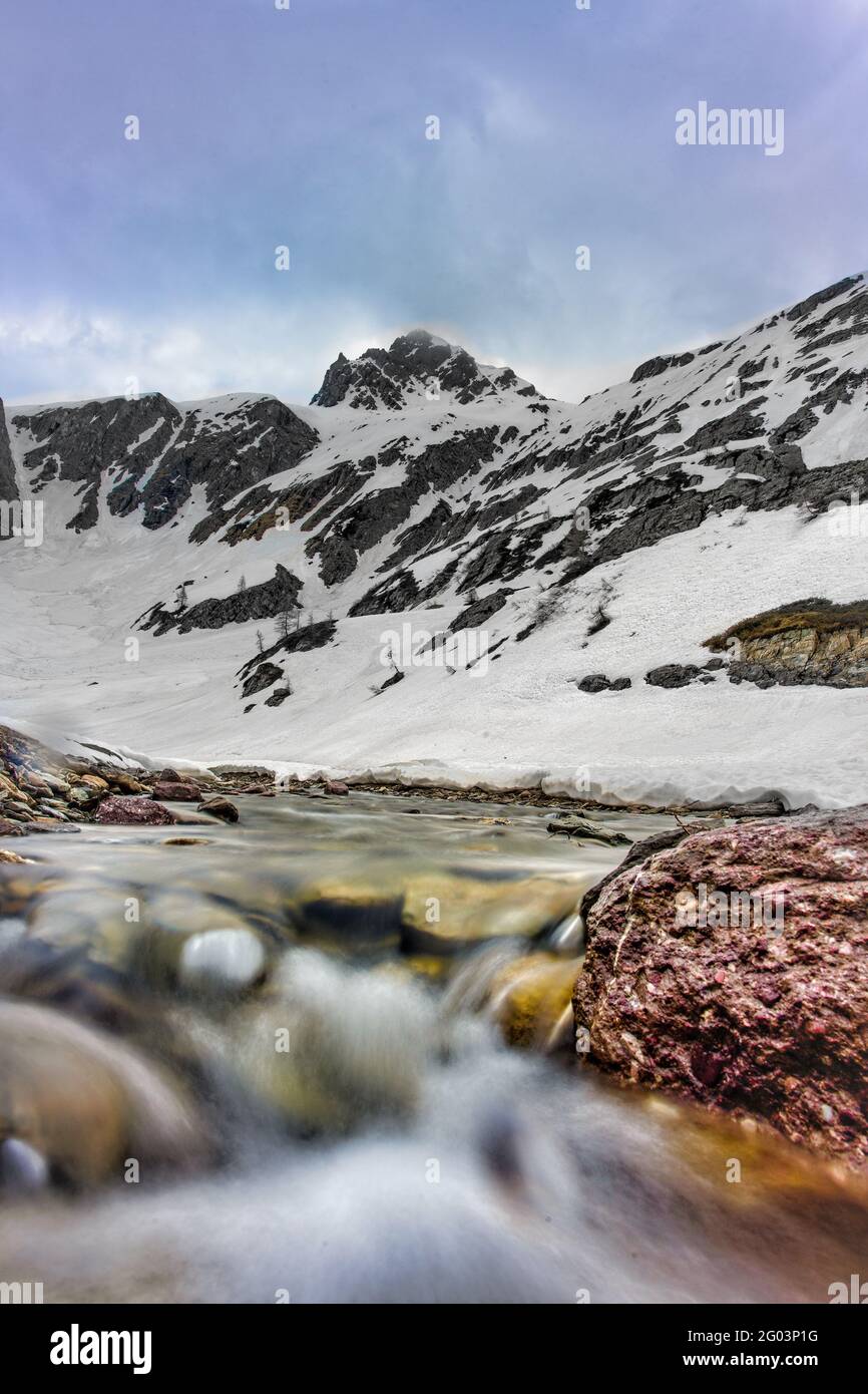 Corso d'acqua che scende dalla montagna dove si trova la neve fuso in primavera Foto Stock