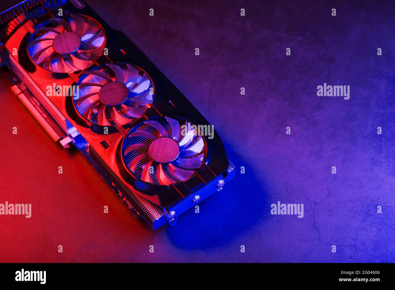 Una scheda grafica con una fila di fan con retroilluminazione cianoica viola in un design futuristico. Potente scheda grafica per videogiochi e cryptocu Foto Stock