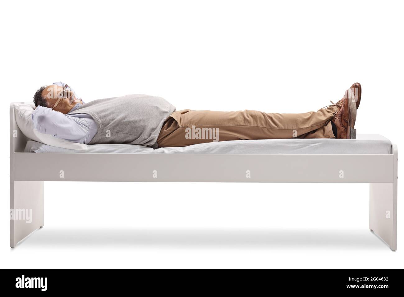 Uomo anziano che dorme su un letto singolo isolato su bianco sfondo Foto Stock