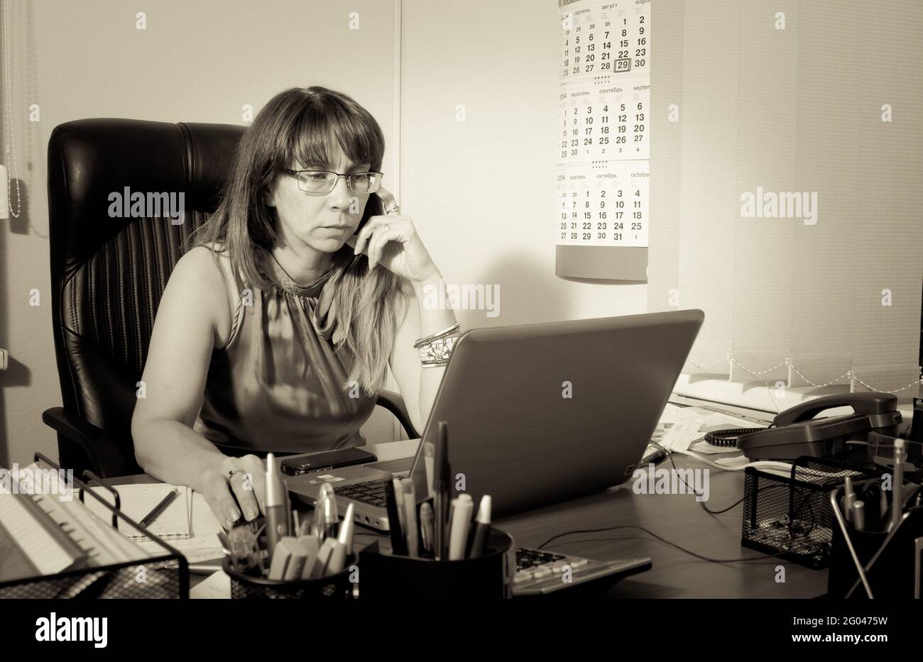 Ritratto di una giovane donna sul suo posto di lavoro in ufficio. Concetto di stile di vita delle persone che lavorano in uffici moderni sotto la luce naturale. Foto Stock