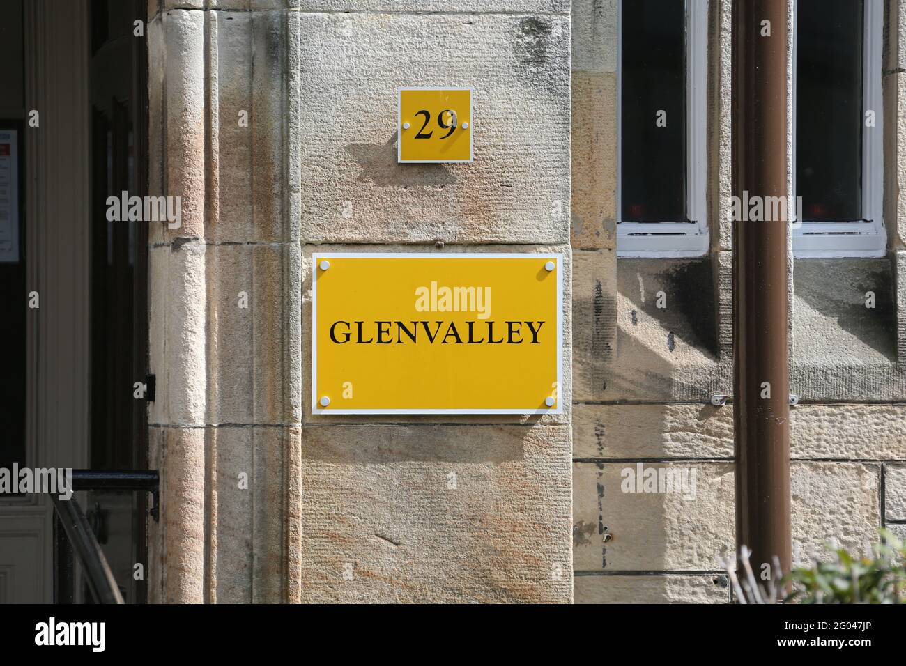 Quarrier's Village, Kilmacolm, Inverclyde , Renfrewshire ,Scozia, Regno Unito. Casa di colore giallo brillante numero 29 e nome casa Glenvalley Foto Stock