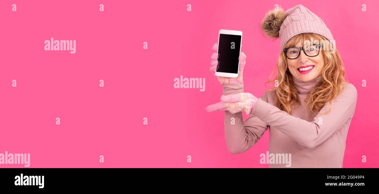 donna adulta o anziana con telefono cellulare su sfondo a colori con spazio per testo o annunci Foto Stock