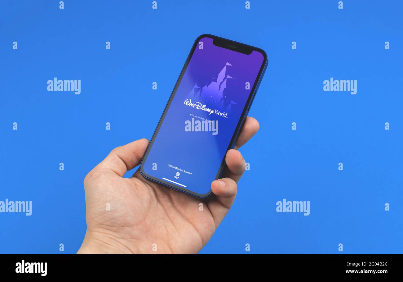 Kharkov, Ucraina - 28 maggio 2021: Uomo tenere telefono cellulare con l'app Disney World, logo di applicazioni Disney su sfondo blu Foto Stock