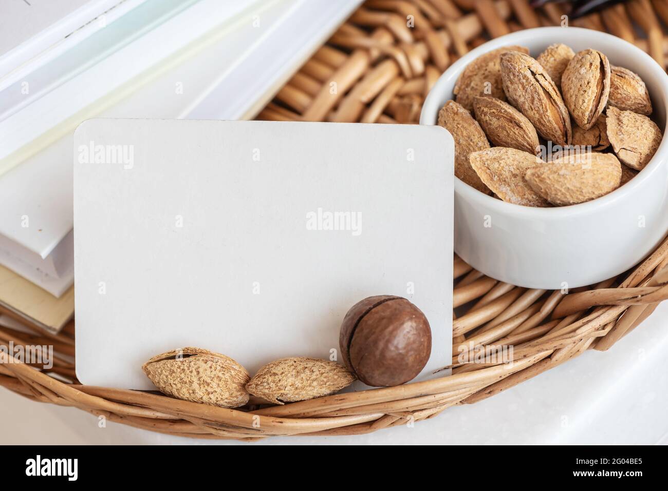 Biglietto da visita con mandorle e noci di macadamia sul vassoio di vimini Foto Stock