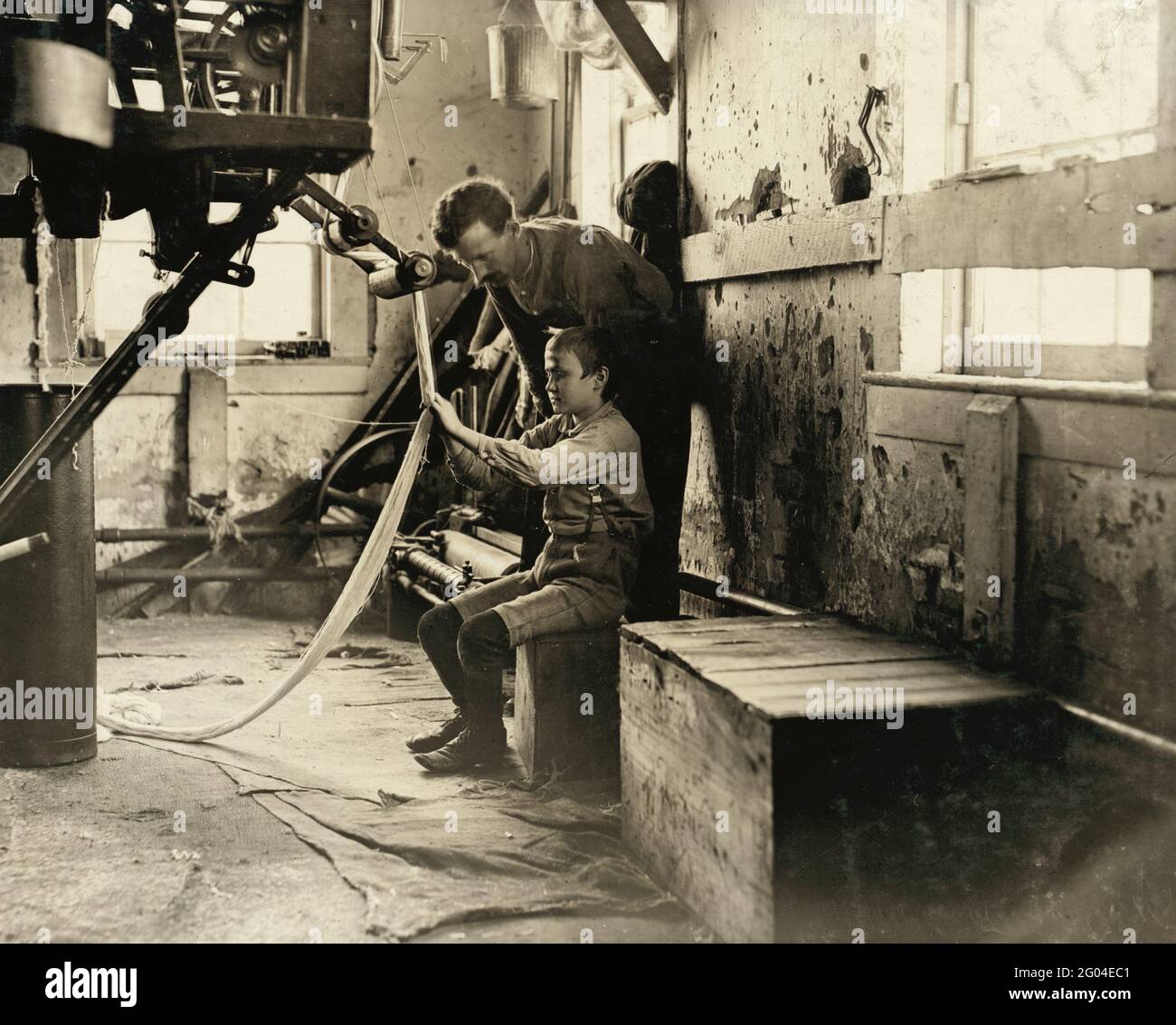 Lavoro minorile: Un ragazzo che lavora su una macchina da orditura Foto Stock