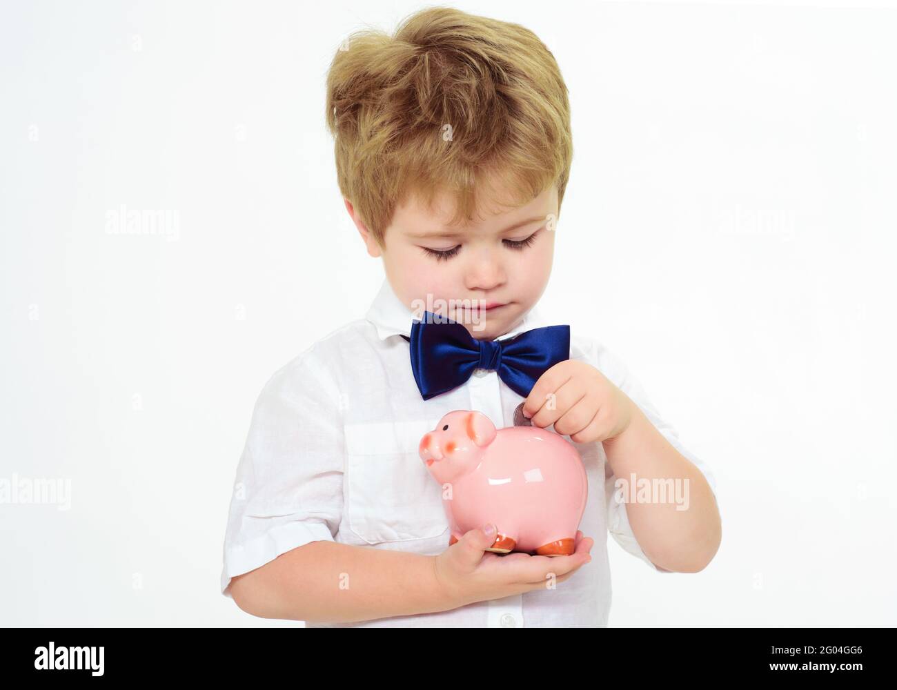 Il ragazzino mise la moneta in una banca di porcellini. Concetto di risparmio. Finanza. Bambino con Moneybox. Pubblicità bancaria. Foto Stock