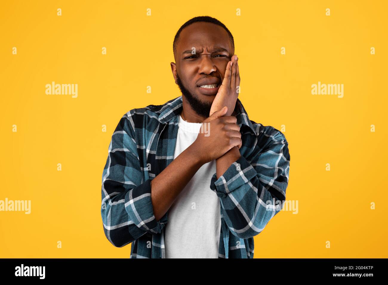 African American Man con dolore dentale che tocca la guancia, sfondo giallo Foto Stock