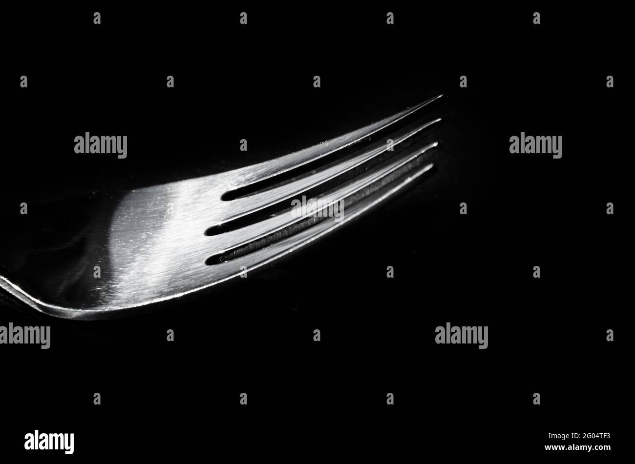 Primo piano di una forchetta di metallo su sfondo nero Foto Stock