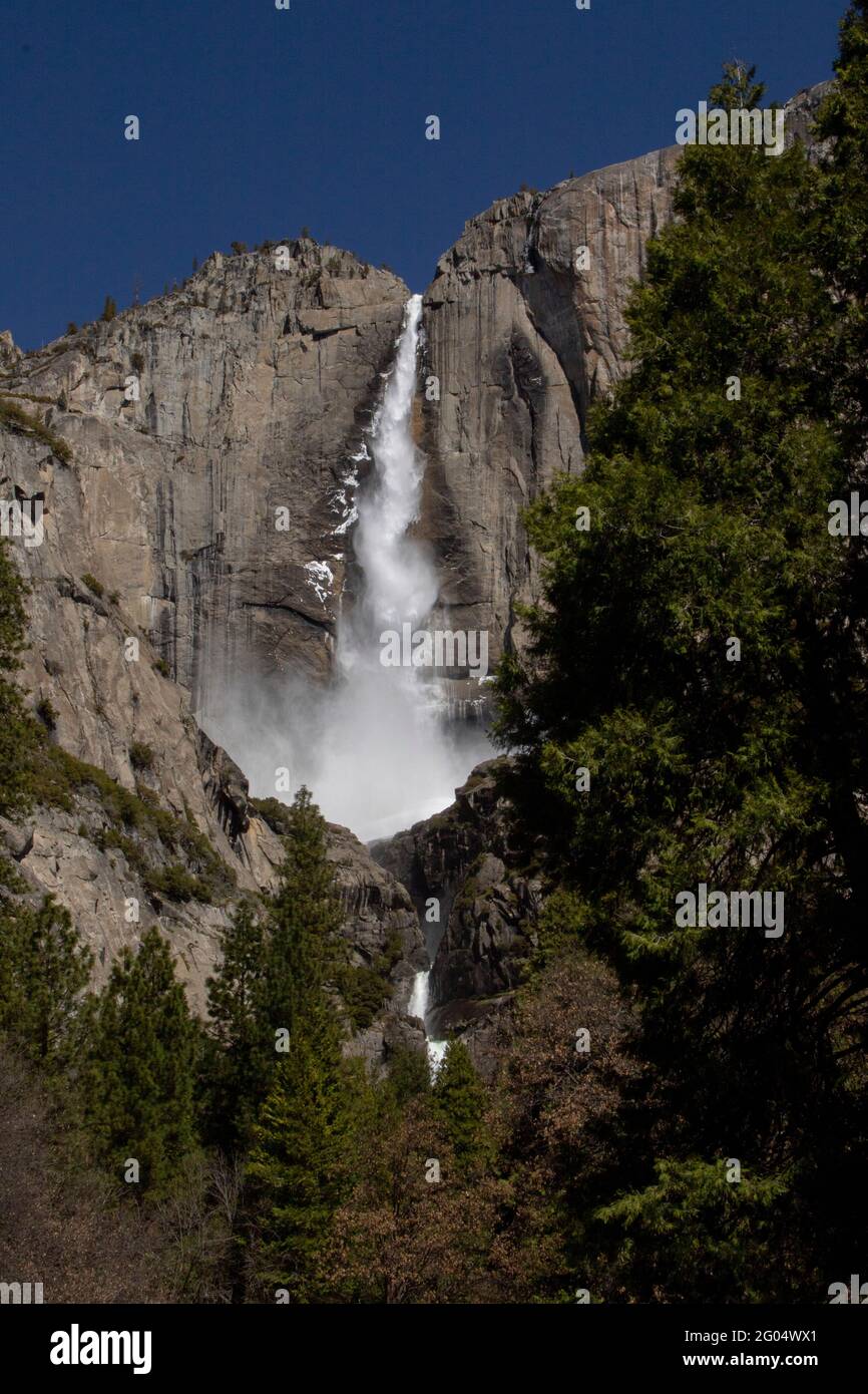 Scarichi di neve sciolta nel tardo inverno attraverso le iconiche e popolari cascate Upper e Lower Yosemite Falls all'interno del Parco Nazionale Yosemite nella contea di Mariposa, California. Foto Stock