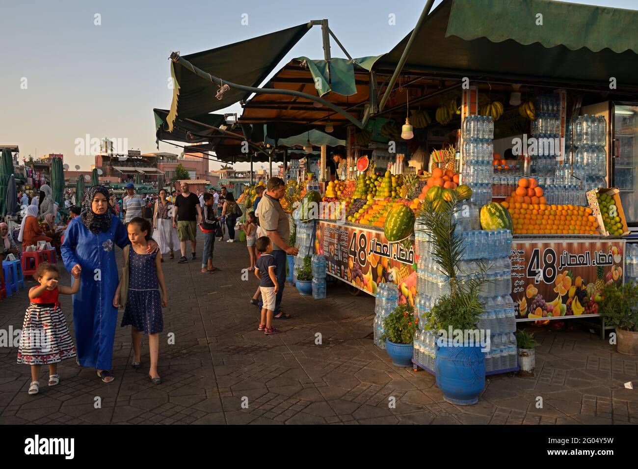 Una famiglia tradizionale nella vivace piazza Jemaa el-Fnaa durante il tramonto, Marrakech ma Foto Stock