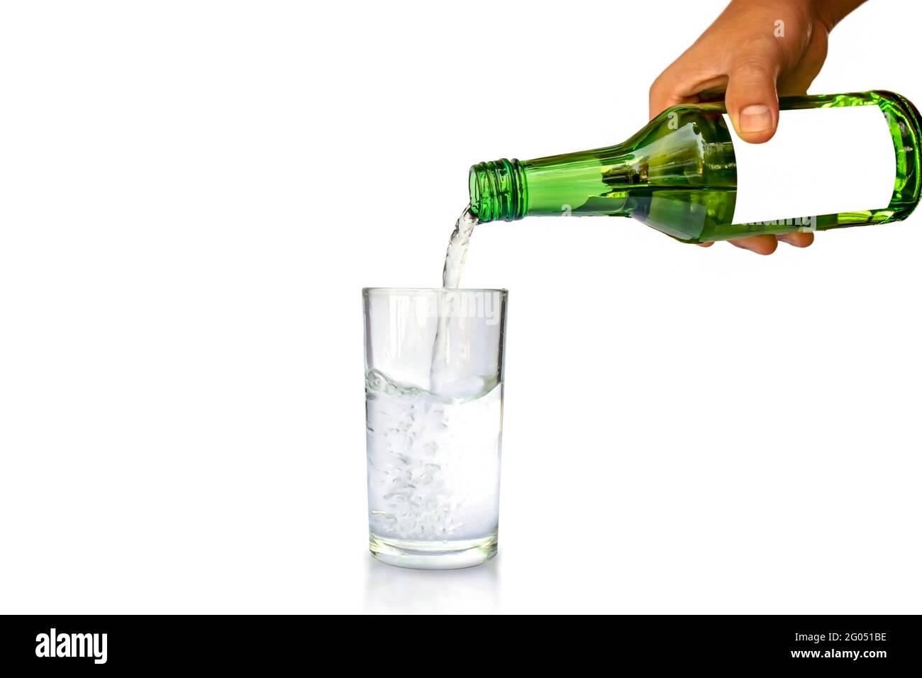 Concetto di stile di vita sano. Mano di giovane donna che tiene una bottiglia per versare l'acqua di vetro separatamente su sfondo bianco. Foto Stock