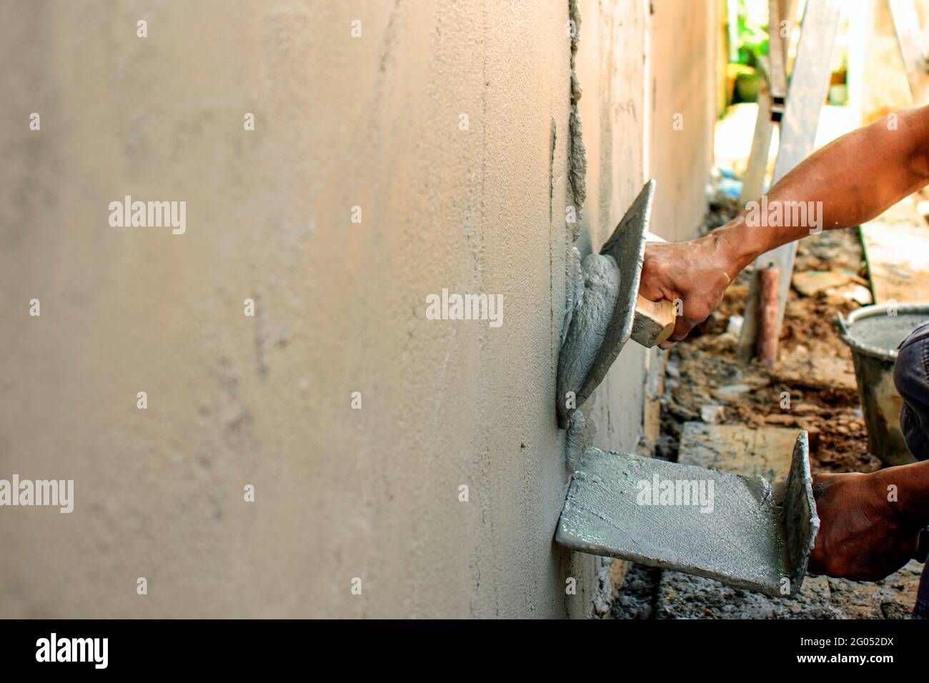 Miglioramento domestico e concetto di miglioramento. Primo piano di lavoratori intonacando muri per costruire case. Foto Stock