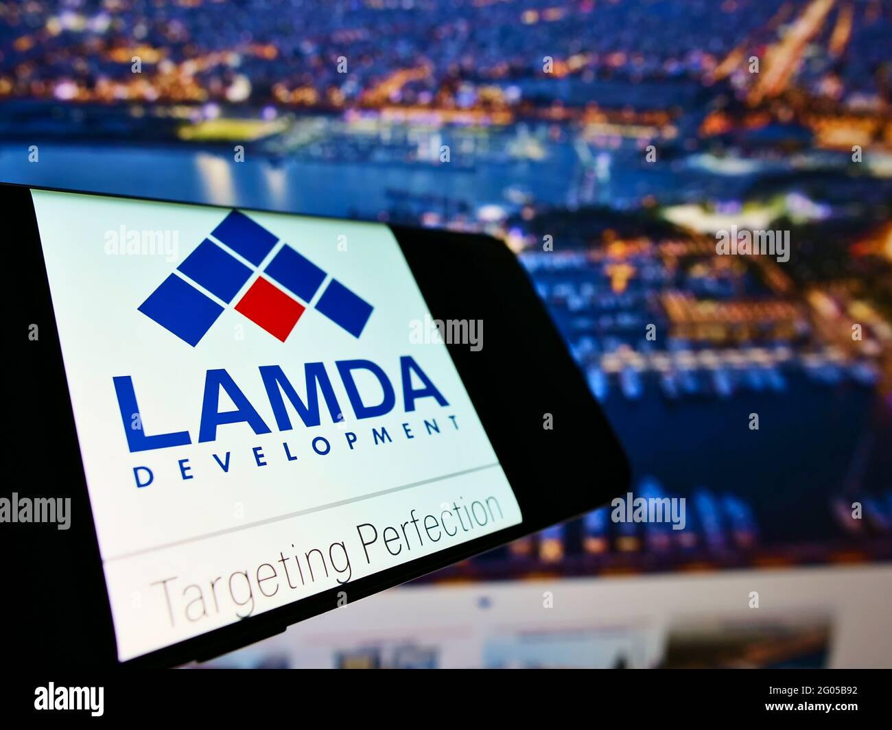 Smartphone con logo aziendale della società immobiliare greca LAMDA Development SA sullo schermo di fronte al sito web. Mettere a fuoco al centro-sinistra del display del telefono. Foto Stock