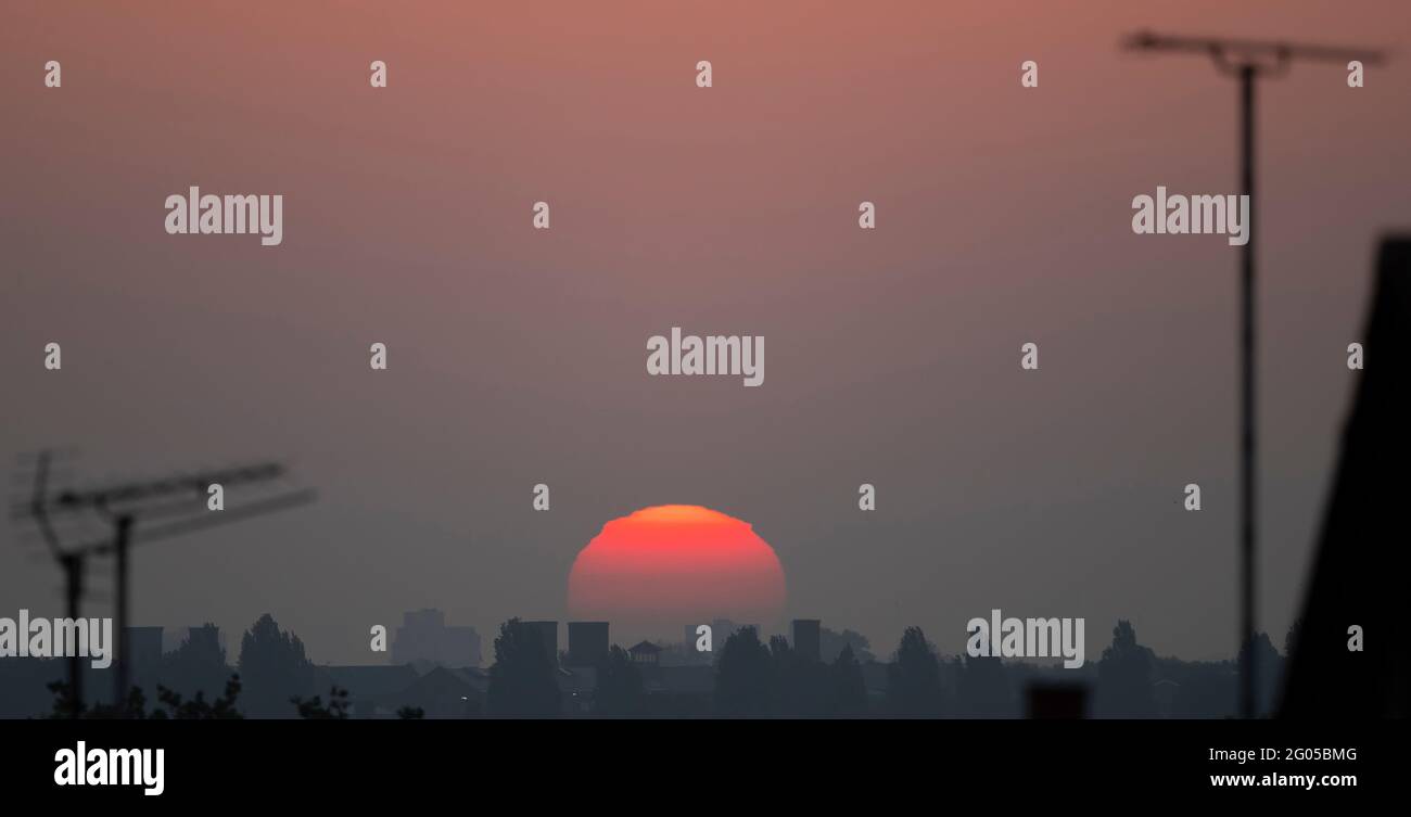 Wimbledon, Londra, Regno Unito. 1 giugno 2021. Il sole sorge contorde di forme mentre si muove attraverso strati spessi di atmosfera vicino all'orizzonte su Londra prima di iniziare un giorno di mini temperature di onda di calore. Credit: Malcolm Park/Alamy Live News. Foto Stock