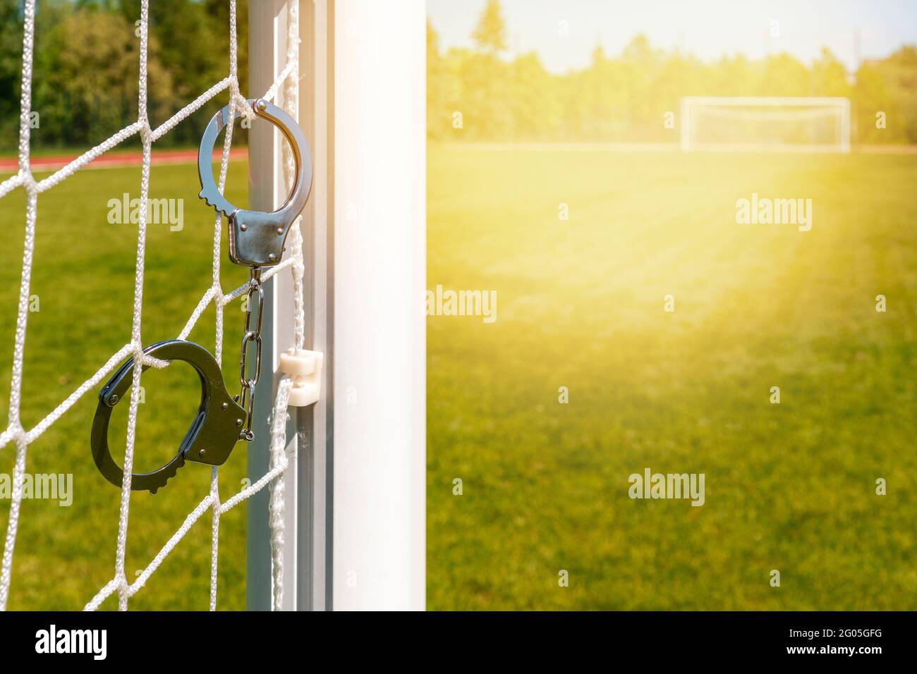 Truffa con il calcio o la corruzione del gioco di calcio. Manette appese alle partite di calcio Foto Stock