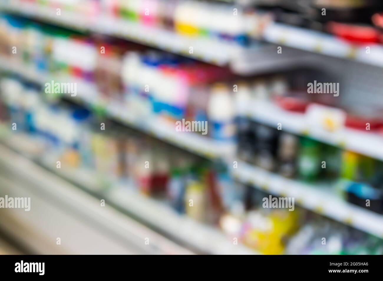 bottiglie di prodotti lattiero-caseari sul ripiano frigorifero in background supermercato Foto Stock