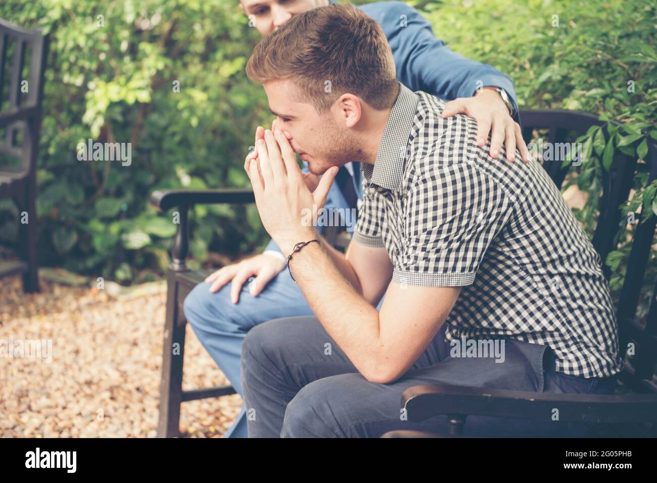 Ragazzi che condividono problemi di vita sempre supportano i migliori amici. Amici che si abbassano cuore rotto. Uomo triste seduto all'aperto nel parco sensazione di tristezza ha una p Foto Stock