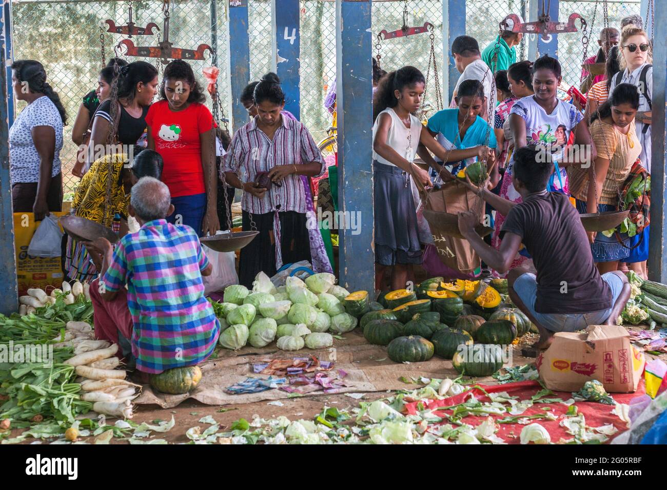 I clienti dello Sri Lanka si sono affollati intorno a un'affollata bancarella di verdure al mercato, Hikkaduwa, Provincia del Sud, Sri Lanka Foto Stock