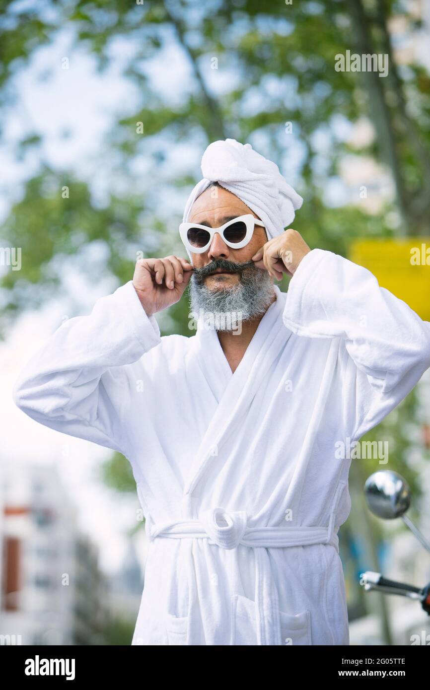 Uomo anziano con barba in accappatoio. Uomo in asciugamano e accappatoio in  strada con occhiali da sole Foto stock - Alamy