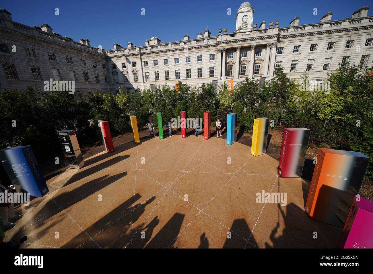 I visitatori che interagiscono con 17 pilastri specchiati che rappresentano gli obiettivi globali delle Nazioni Unite, nell'installazione centrale di Forest for Change - costituita da 400 alberi nel cortile della Somerset House - durante una telefonata per la London Design Biennale alla Somerset House di Londra, Che va dal 1 ° al 27 giugno. Data immagine: Martedì 1 giugno 2021. Foto Stock