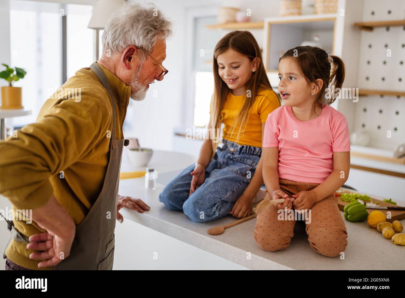 Nonno sta scolding le sue ragazze del grandchildrens. Famiglia, punizione, concetto di disciplina Foto Stock