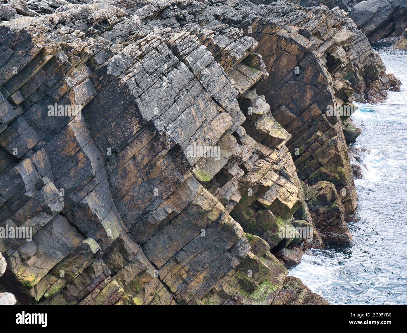 Strati rocciosi ripidamente inclinati e fratturati sulla Ness of Burgi, South Shetland, UK - formazione di arenaria di Hayes - Bedrock sedimentario Foto Stock