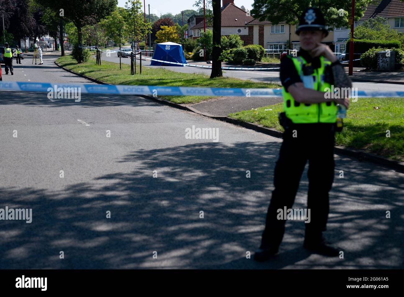 Un ufficiale di polizia si trova vicino alla scena di College Road, Kingstanding, a nord di Birmingham, dove un ragazzo di 14 anni è morto dopo essere stato pugnalato il lunedì sera. La polizia ha avviato un'indagine sugli omicidi e sta cacciando fino a sette persone in relazione all'attacco. Data immagine: Martedì 1 giugno 2021. Foto Stock