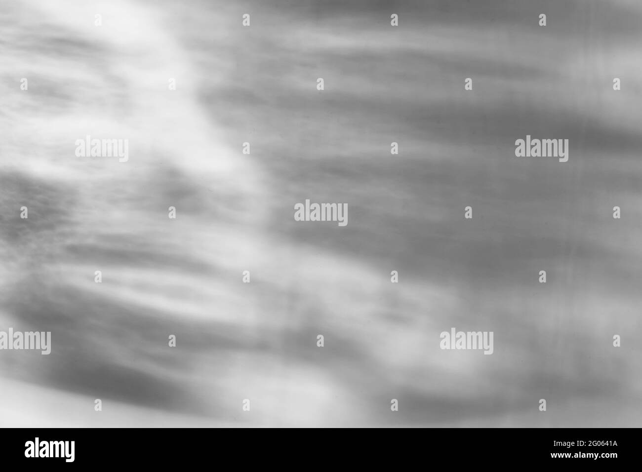 Il vetro lascia cadere l'ombra diagonale e l'effetto caustico leggero su una parete bianca. Caustiche formate dalla rifrazione del sole in una bottiglia su un tavolo luminoso. Raggi, Foto Stock