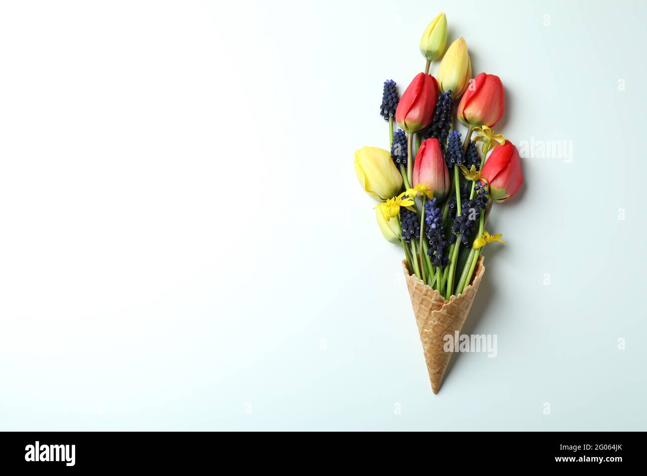 Cono waffle con fiori su sfondo bianco Foto Stock