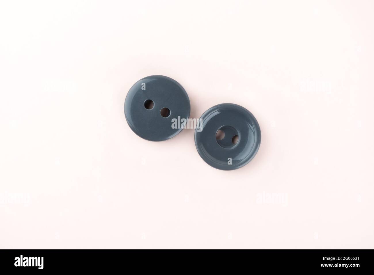 Due bottoni grigi in plastica su entrambi i lati. Accessori per cucire. Spazio di copia. Foto Stock