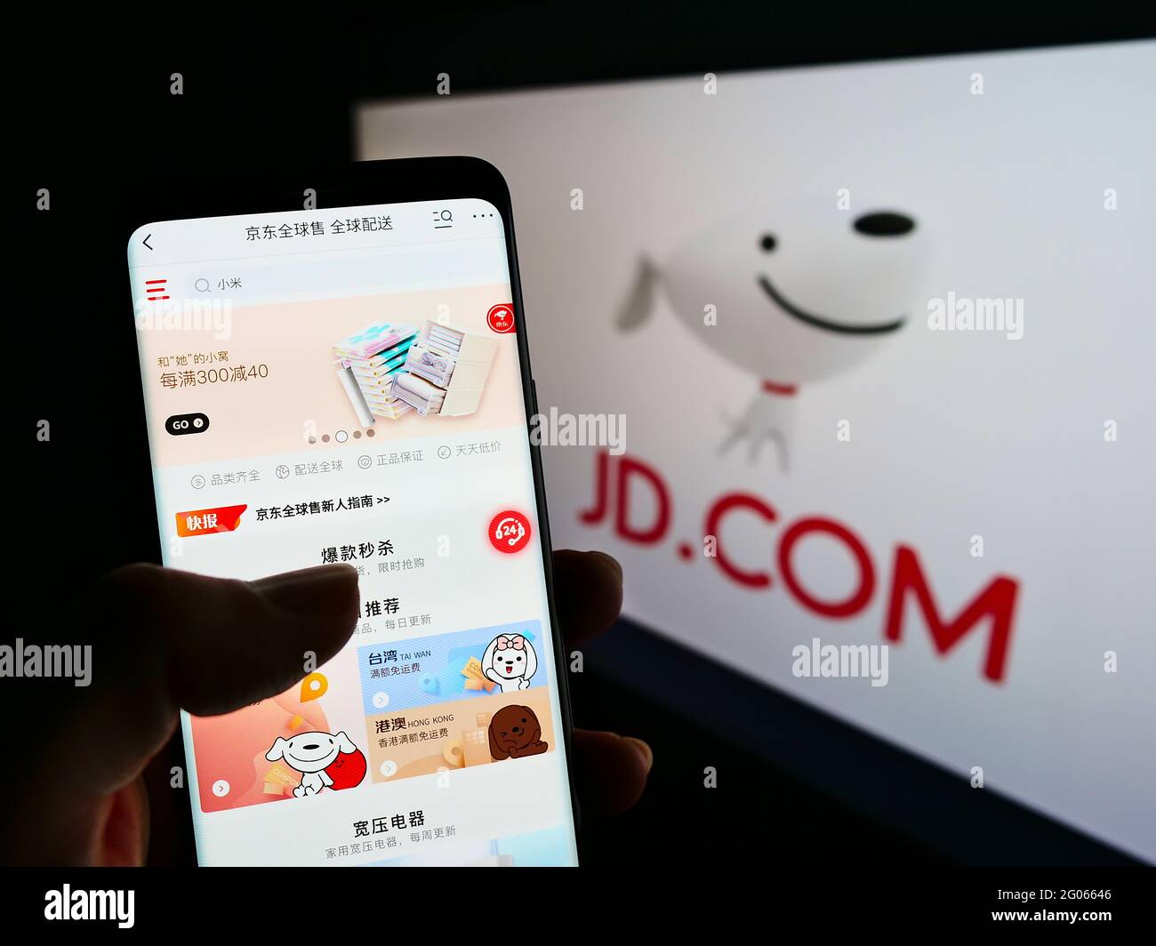 Persona che tiene il telefono mobile con il Web site della società cinese di e-commercio JD.com Inc. Sullo schermo davanti al logo. Mettere a fuoco il centro del display del telefono. Foto Stock