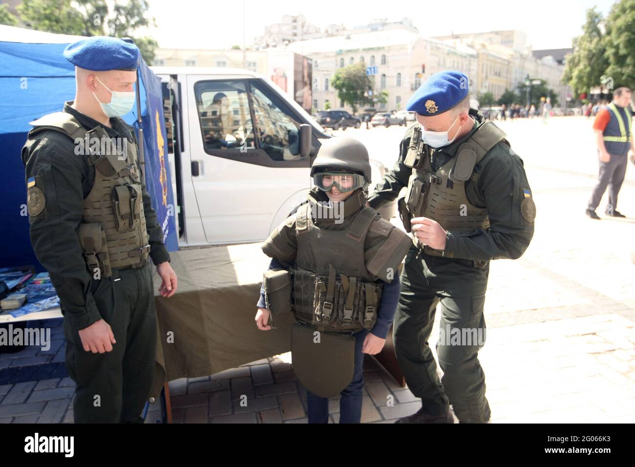 KIEV, UCRAINA - 1 GIUGNO 2021 - gli ufficiali della Guardia Nazionale aiutano un ragazzo a provare gli attrezzi durante la celebrazione della Giornata Internazionale dei Bambini in Piazza Sofiska Foto Stock