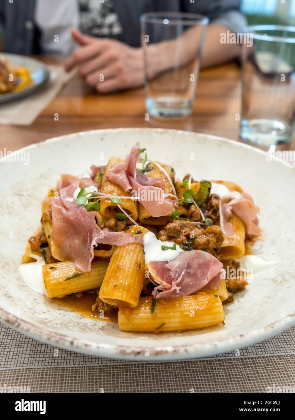 Elegante piatto a base di salsa bolognese, rigatoni, prosciutto, erbe fresche e un dollop di ricotta. Foto Stock