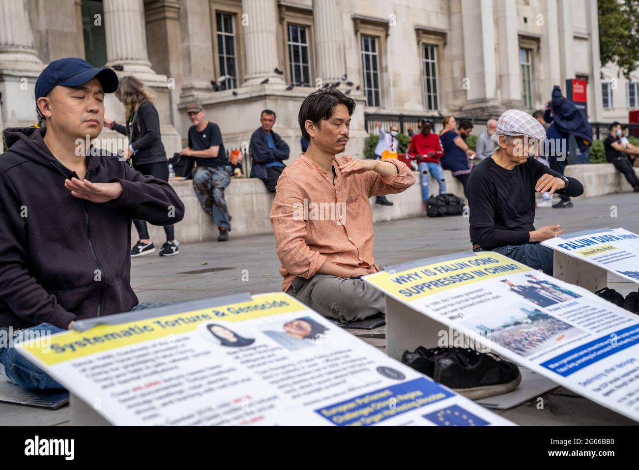 LONDRA, UK - gli uomini asiatici meditano durante una manifestazione contro la persecuzione e la tortura dei praticanti di Falun Gong da parte del Partito comunista cinese Foto Stock